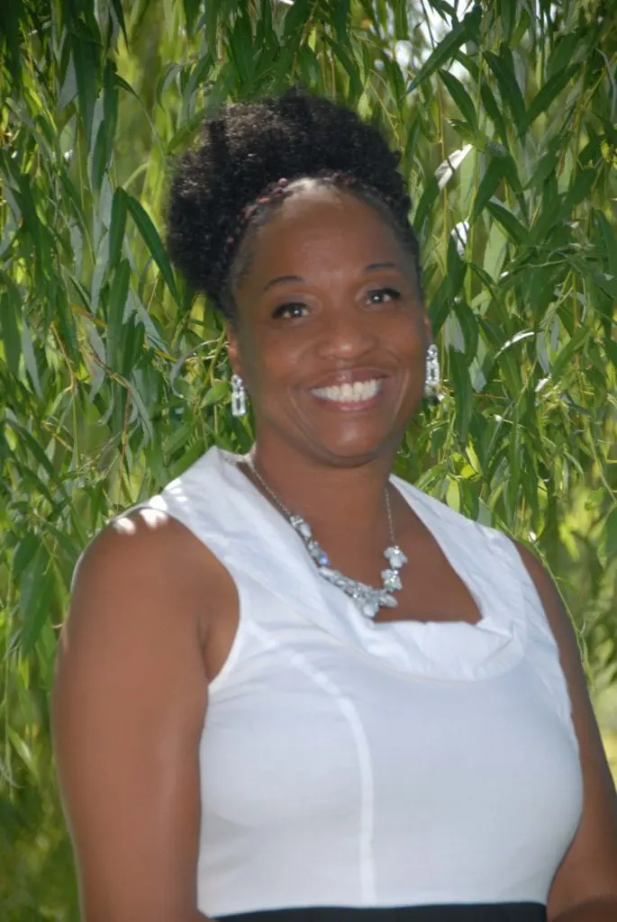 Smiling woman in white top by willow
