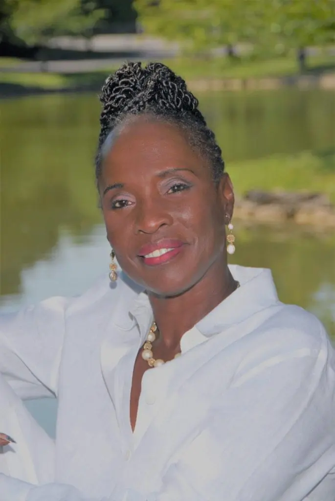 Smiling woman wearing pearls by pond